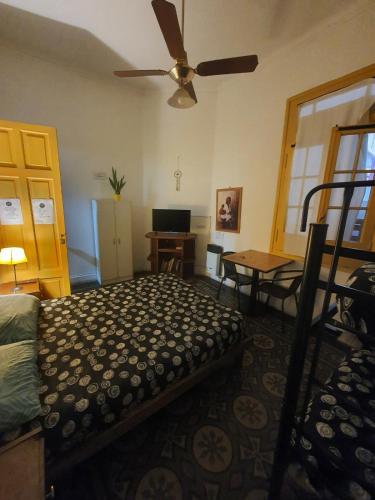 um quarto com uma cama e uma ventoinha de tecto em Hostel Morada Roots em Córdoba