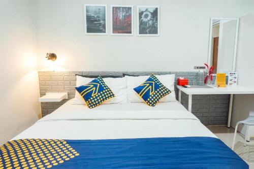 1 cama con almohadas azules y blancas en una habitación en Rumah Teteh Syariah, en Bandung