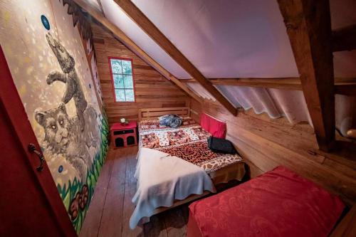 a attic room with two beds in a log cabin at Cabaña Colibri naturaleza vista Laguna de la Cocha in Pasto