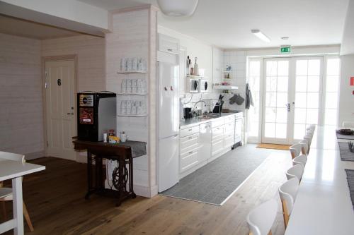 cocina con armarios blancos, mesa y sillas en Låsta Gårdshotell, en Strängnäs