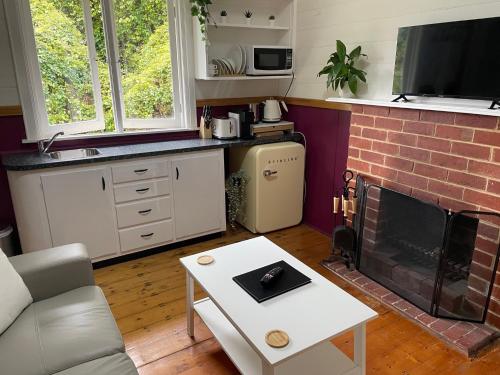 uma sala de estar com um sofá e uma lareira em The Mulberry Cottage em The Patch
