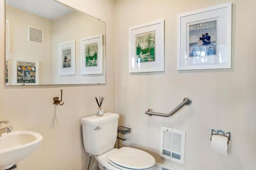 a white bathroom with a toilet and a sink at The American Dream in Lakewood