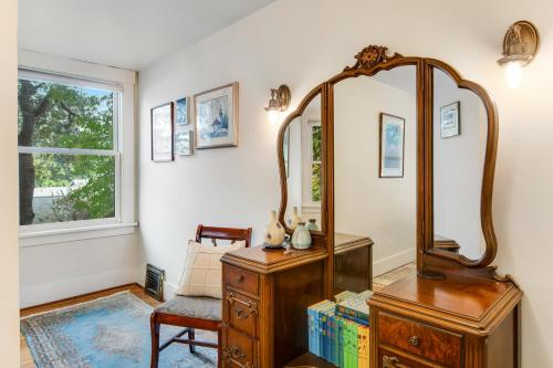 a room with a mirror and a dresser and a chair at The American Dream in Lakewood