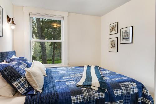 a bedroom with a blue and white bed with a window at The American Dream in Lakewood