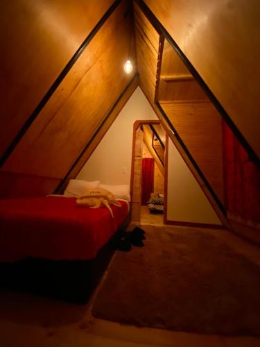 Zimmer mit einem roten Bett im Dachgeschoss in der Unterkunft Chalet Villa Ines un paraiso en las montañas in Duitama