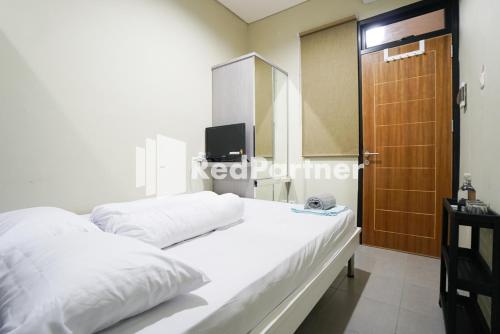 Postel nebo postele na pokoji v ubytování Tomang Gelong Guest House Syariah Mitra RedDoorz