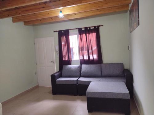 - un salon avec un canapé et une fenêtre dans l'établissement Aladdín Departamentos, à Luján de Cuyo