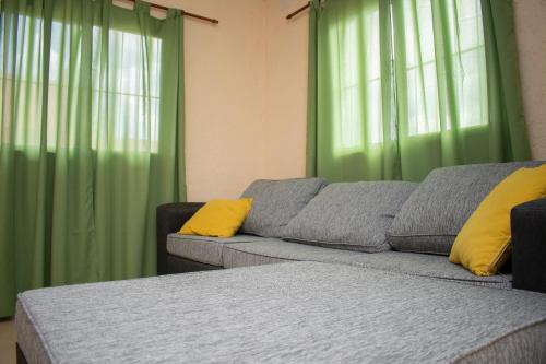 a living room with a couch and green curtains at Aladdin Loft in Ciudad Lujan de Cuyo