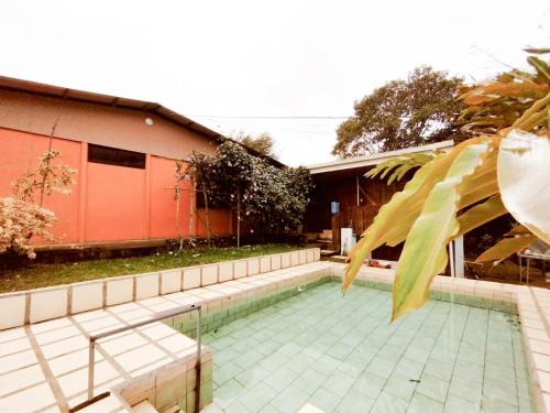 una piscina di fronte a una casa di Hospedaje Luis & Ana a Pejibaye