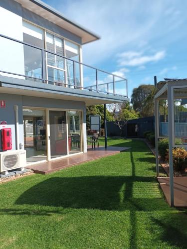 a house with a large yard with a gazebo at Grandeur Holiday Units in Merimbula