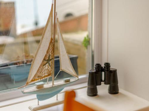 a small sail boat sitting on a window sill at Seaside in Ventnor