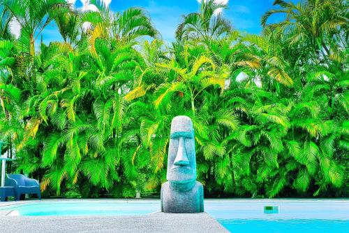 a statue of a head next to a pool at GREEN LORD DOMAINE - Lodges Piscine & Spa - Bar & Lounge - Restaurant gastronomique in Lamentin