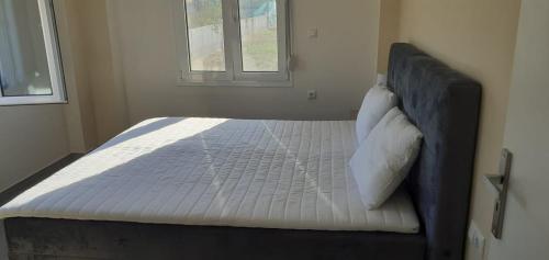 a large bed in a bedroom with a window at Georgiadis House in Ammoudia