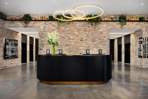 a lobby with a black reception desk with a chandelier at The Elser Hotel Miami in Miami