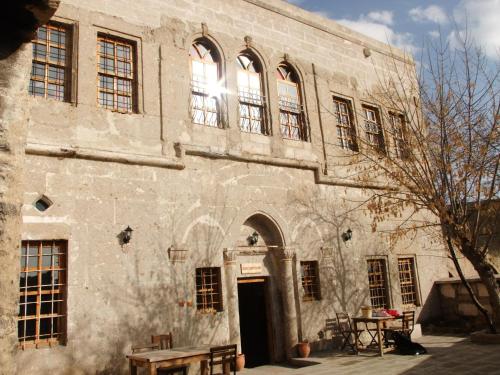 an old stone building with a wooden bench in front of it at Kapadokya Ihlara Konakları Otel Konak Odaları in Guzelyurt