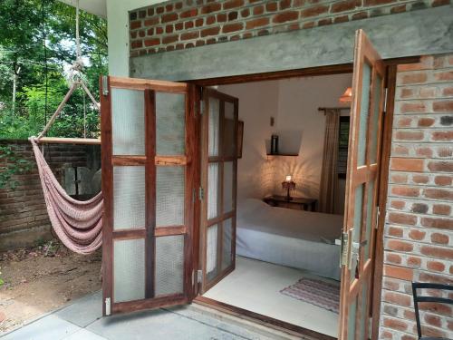 an open door leading to a bedroom with a hammock at Isai Ambalam guest house in Pondicherry