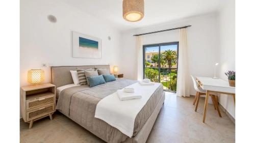 a bedroom with a bed and a table and a desk at Casa Palmeira in Lagos