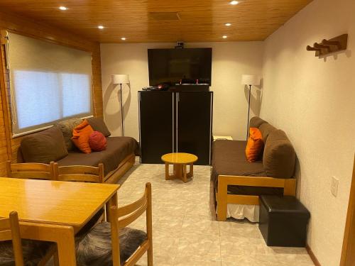 a living room with a couch and a table at Departamento en Edificio Atenas con excelentes Vistas in Las Lenas