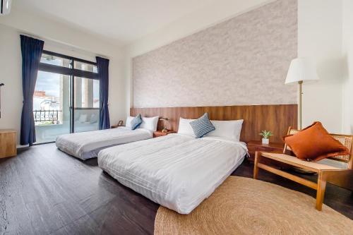 a hotel room with two beds and a window at Choco Style Inn in Taitung City