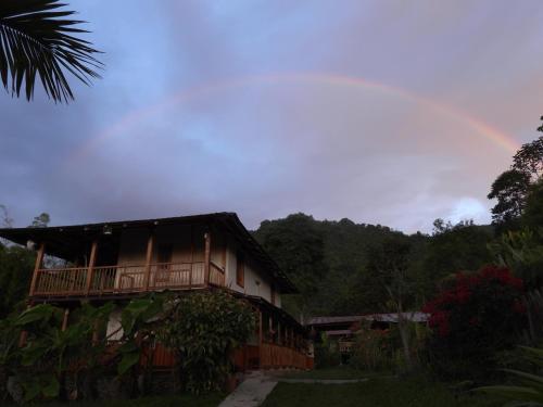 a rainbow in the sky above a house at Finca TRADICIONAL EL OTOÑO in Pijao