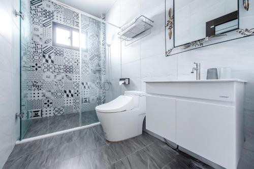 a bathroom with a toilet and a sink and a shower at Choco Style Inn in Taitung City