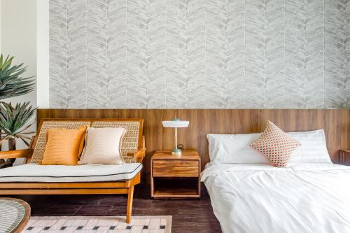 台東市的住宿－H& Choco style inn，一间卧室配有两张床和椅子