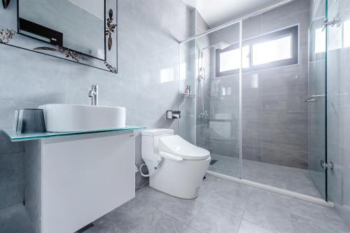 a bathroom with a toilet and a sink and a shower at Choco Style Inn in Taitung City