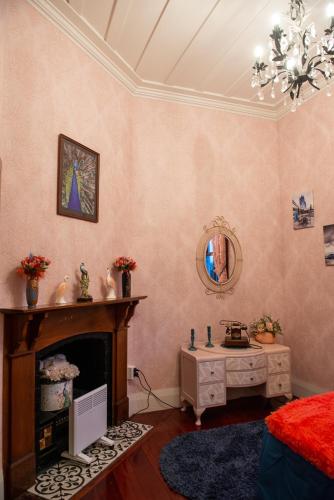 a living room with a fireplace and a mirror at 5-Star OLD POST OFFICE HOLIDAY HOME - 5-7-Bedroom Art Deco Elegance in Owhango