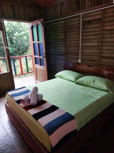 a bedroom with a large bed with a wooden headboard at Las cabañas del escobo - CABAÑA TUCÁN in Nimaima