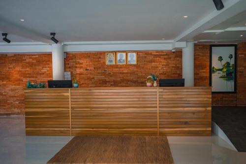 a lobby with a wooden counter in a brick wall at Montagne Boutique in Kampot