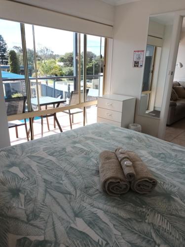 a bedroom with a bed with towels on it at Grandeur Holiday Units in Merimbula