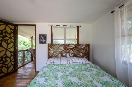 a bedroom with a bed with a green and white comforter at Mountain lake Island Cabin Sierra - for family Getaway in Cavinti