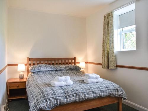 a bedroom with a bed with two towels on it at Uk39800 - Crag Barn in Troutbeck