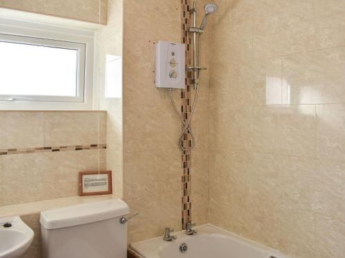 a bathroom with a shower and a toilet and a sink at Uk39800 - Crag Barn in Troutbeck