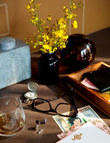 a table with glasses and a vase with yellow flowers at The Langham, Shanghai, Xintiandi in Shanghai