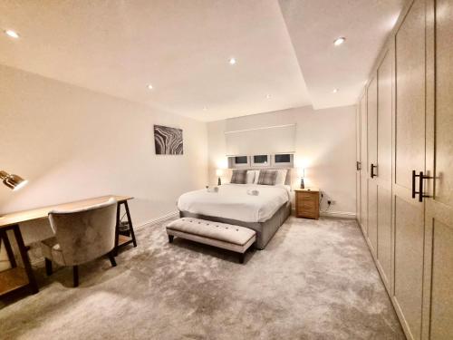 a bedroom with a bed and a desk and a table at The Retreat Birchwood by Kasar Stays in Kent