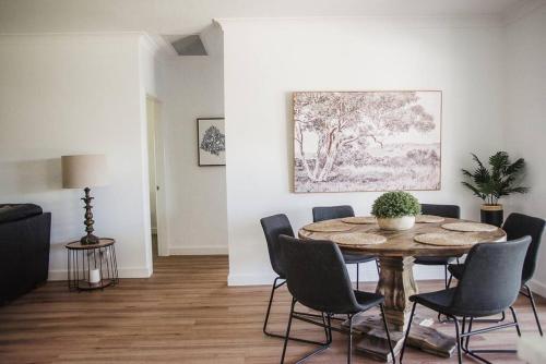 a living room with a wooden table and chairs at Figo Place in Benalla