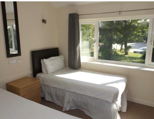1 dormitorio con cama y ventana grande en Atlantic Retreat, en Newquay