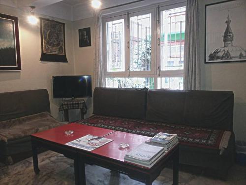 uma sala de estar com um sofá e uma mesa em Imperial House em Kathmandu