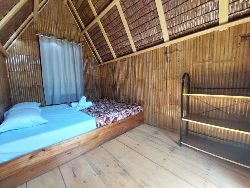 a bedroom with a bed in a straw hut at Russell Place in San Vicente