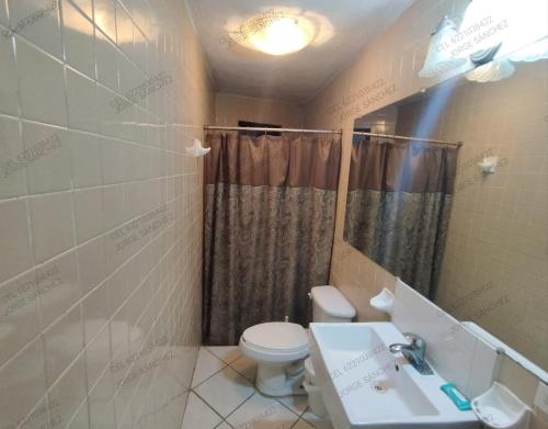 y baño con aseo, lavabo y ducha. en Casa Tecalai 5 en San Carlos