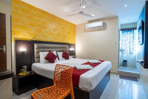 a hotel room with a bed and a chair at Safa Residency in Tiruchchirāppalli