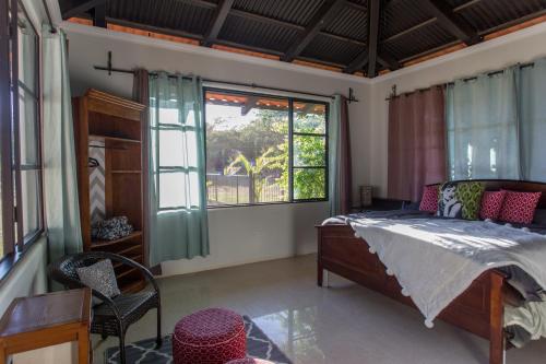 a bedroom with a bed and a large window at Two Acre Private Costa Rican Villa Volcano Views Gym Hot Tub in Atenas