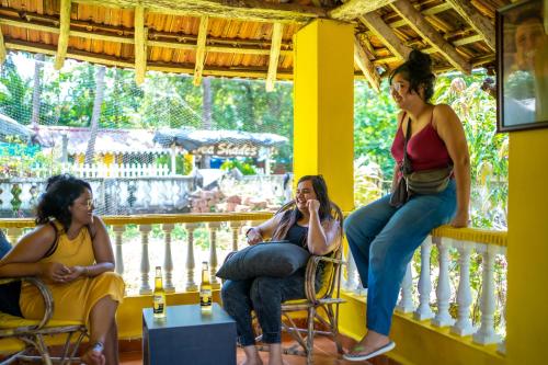 a group of women sitting on a balcony at Whoopers Hostel Palolem in Palolem