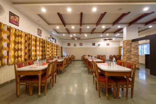 uma sala de jantar com mesas e cadeiras de madeira em Hotel great punjab em Aurangabad