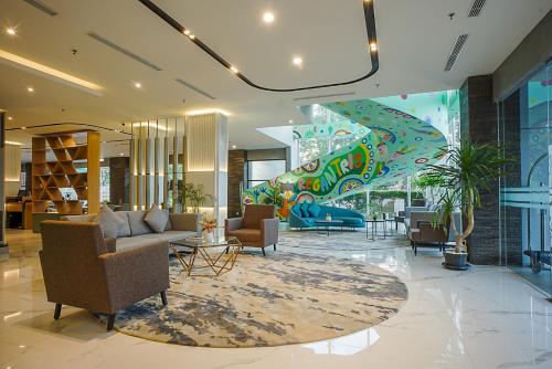 a lobby with a couch and chairs and a mural at Regantris Surabaya in Surabaya