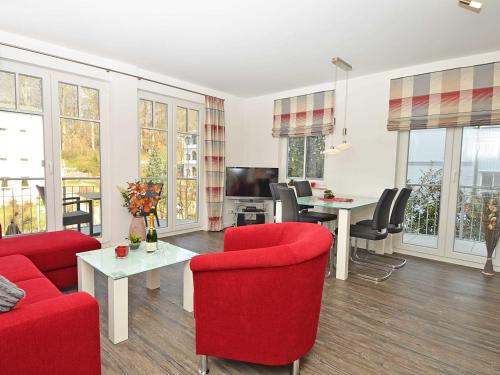 a living room with red chairs and a red couch at Villa Rosa - Apt. 05 in Ostseebad Sellin