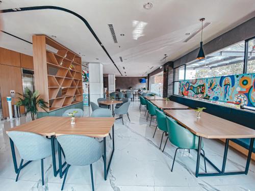 a restaurant with wooden tables and blue chairs at Regantris Surabaya in Surabaya