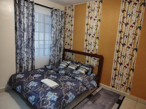a bedroom with a bed and a window with curtains at Peace homes in Nairobi