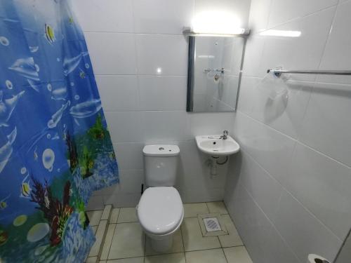 a white bathroom with a toilet and a sink at Peace homes in Nairobi